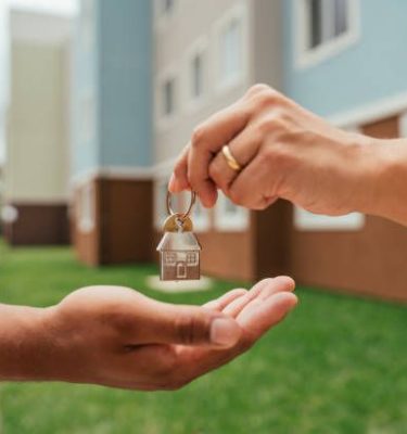 Detail of real estate agent's hands handing over keys