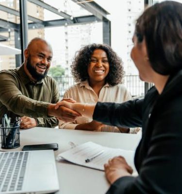 Couple closing real estate contract with real estate agent